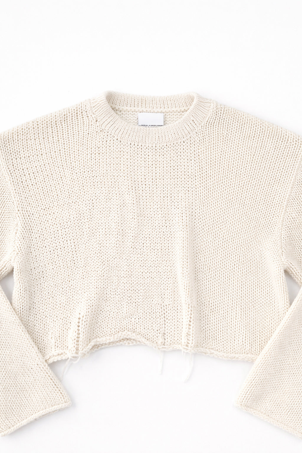Detail front flat lay of cream cotton light weight knit crewneck sweater by Suss Knits