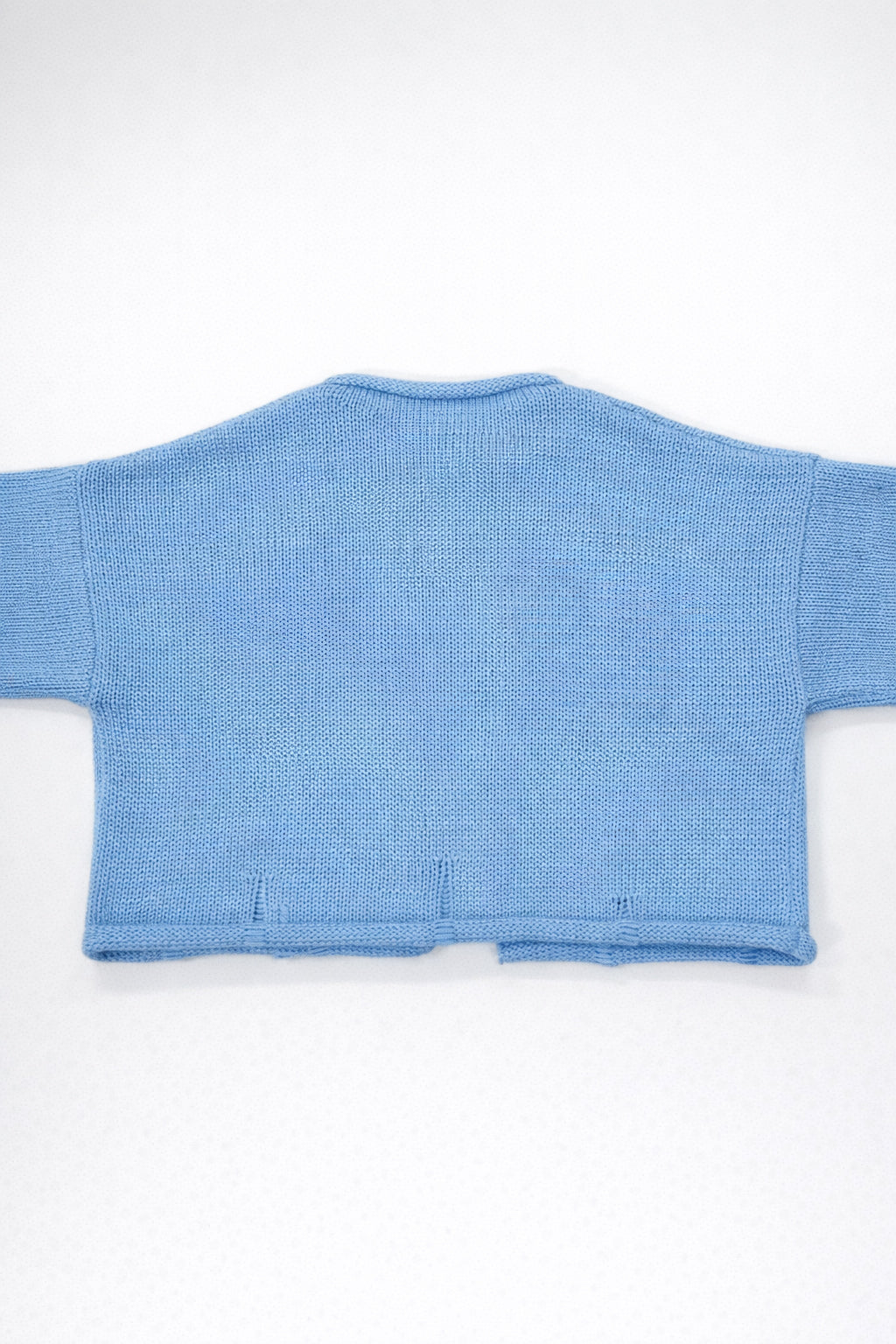 Back view of baby blue cotton cropped knit jacket by Suss Knits