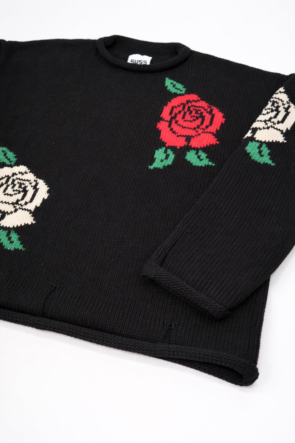 Angle flat lay detail of black cotton knit sweater with rose design by Suss Knits