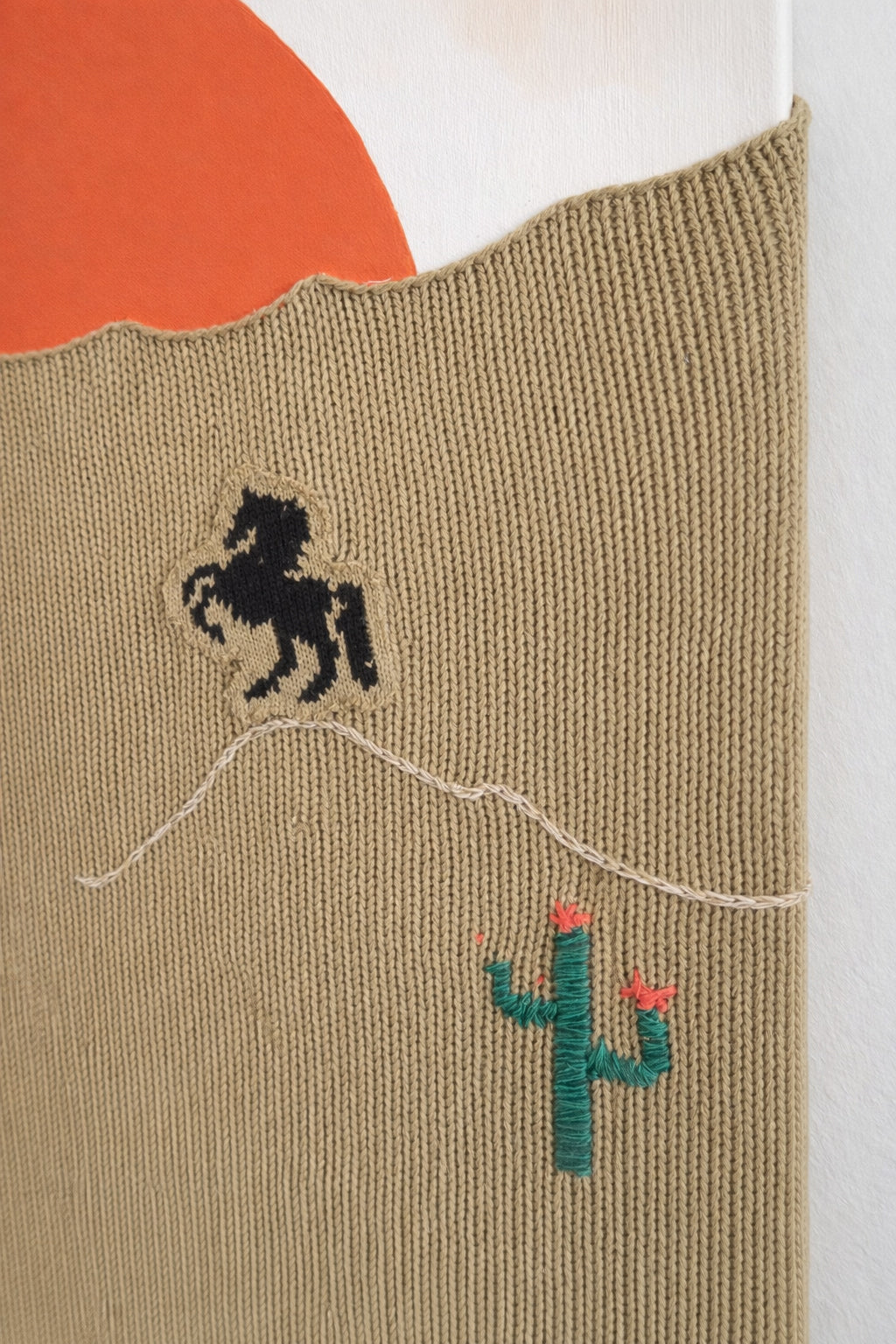 suss knits close up of hand loomed recycled cotton knit panel with embroidered cactus detail