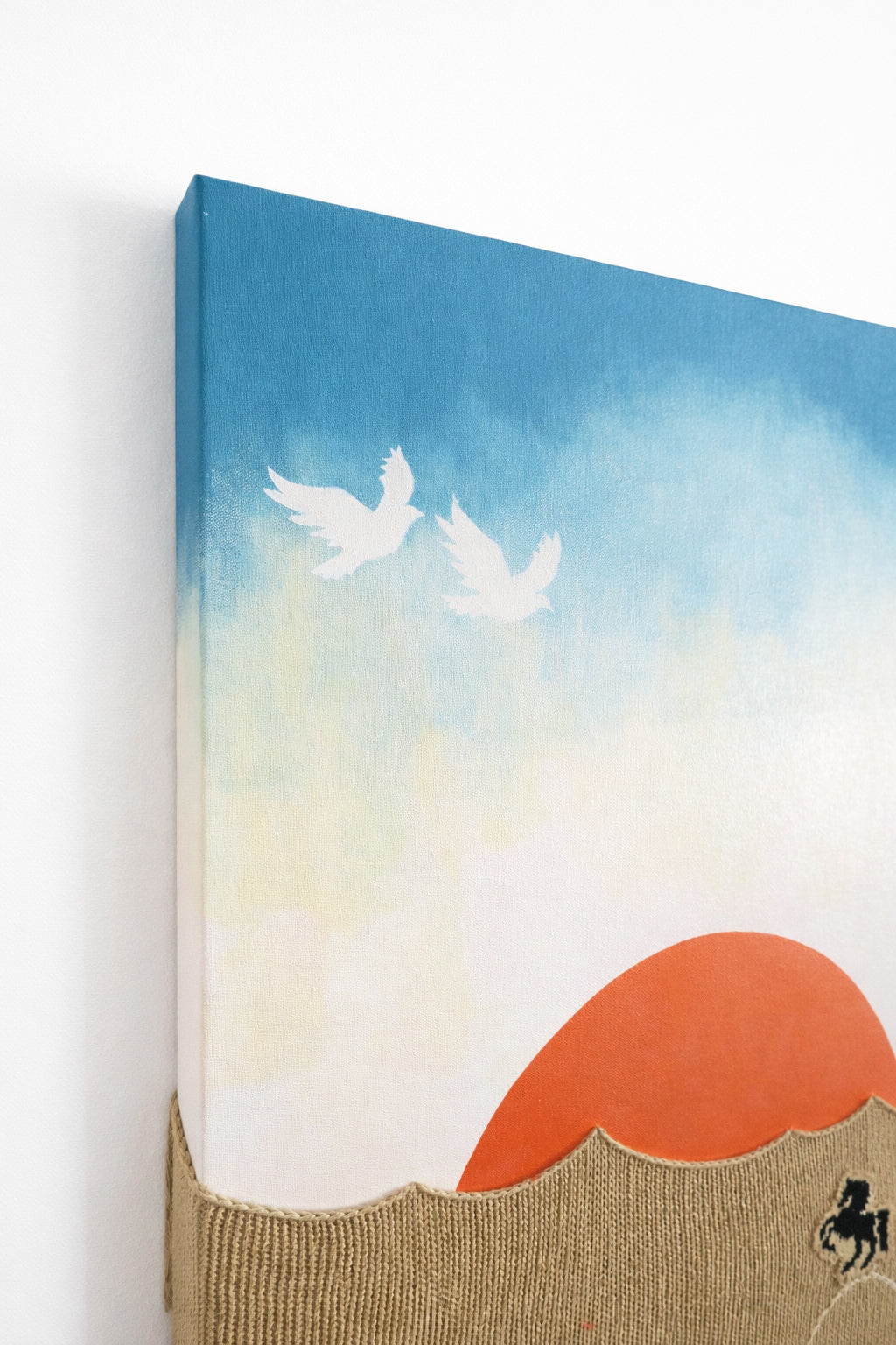 side corner angled view of acrylic painting birds hand loomed textile wall art with desert sunset and embroidered horses