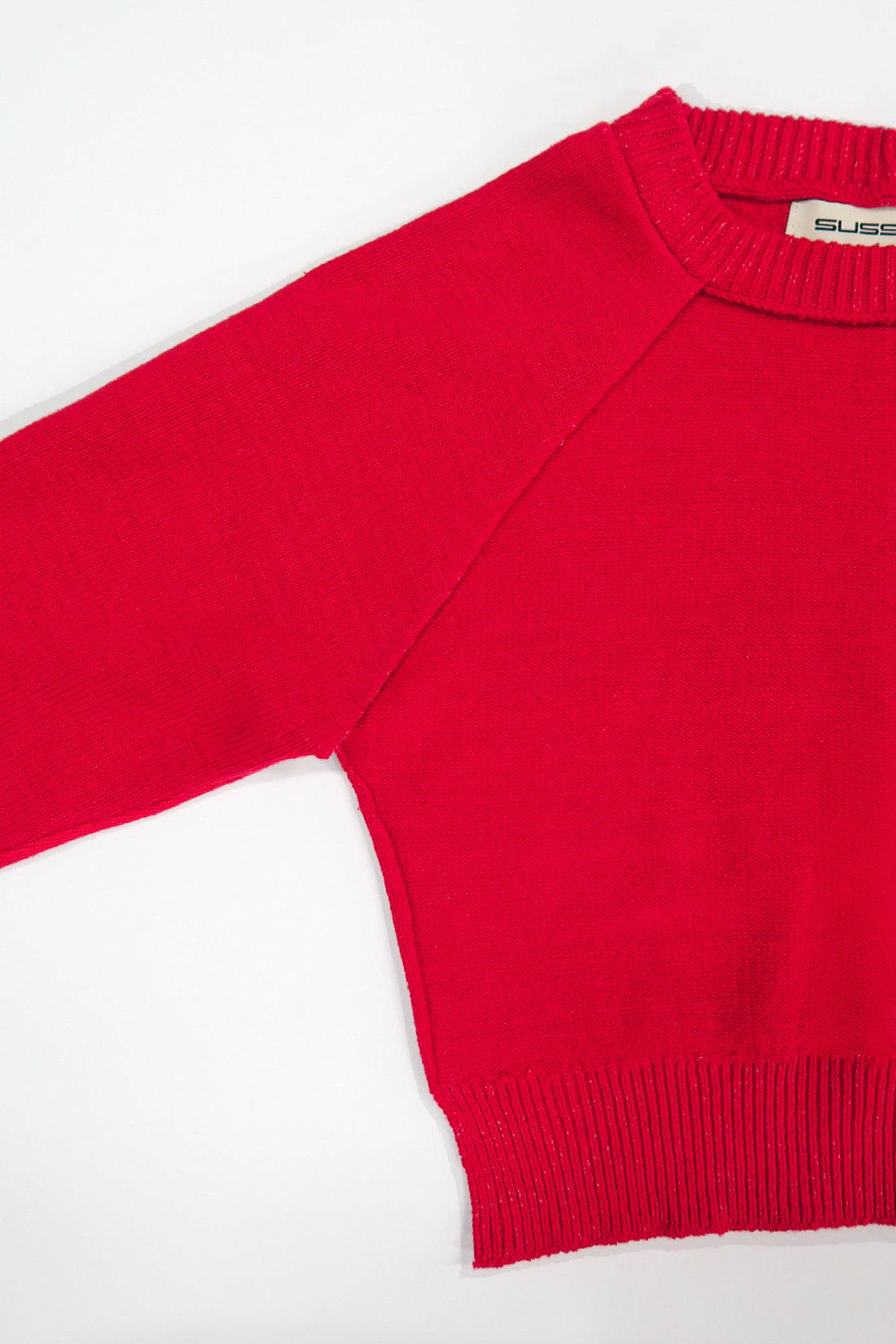 The Suss knits Open Raglan Knit Top in bright red detail photo showing raglan construction and ribbed crewneck
