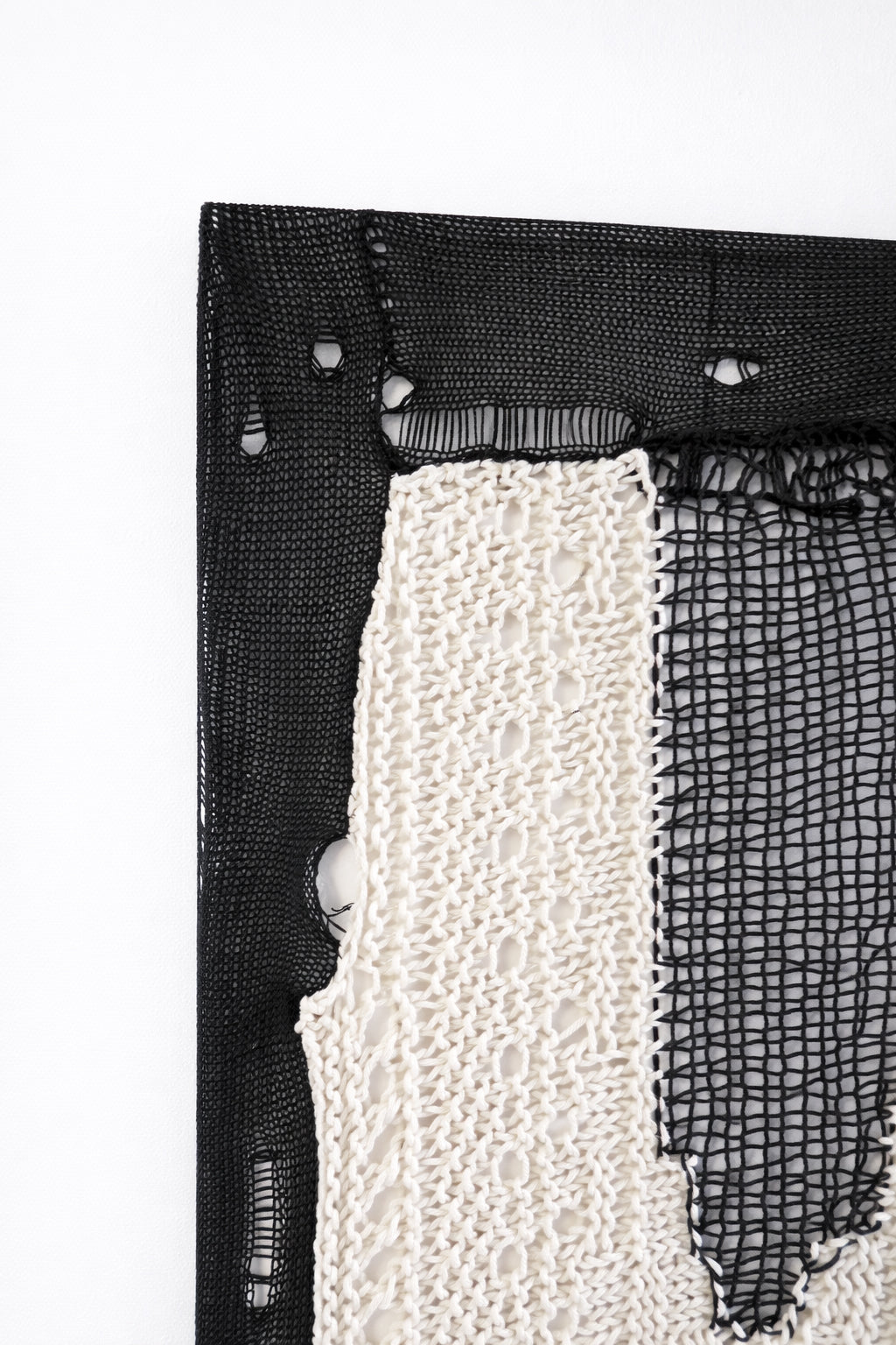 Macro detail of hand lommed cotton yarn corner texture with open stitch pattern in modern abstract textile artwork