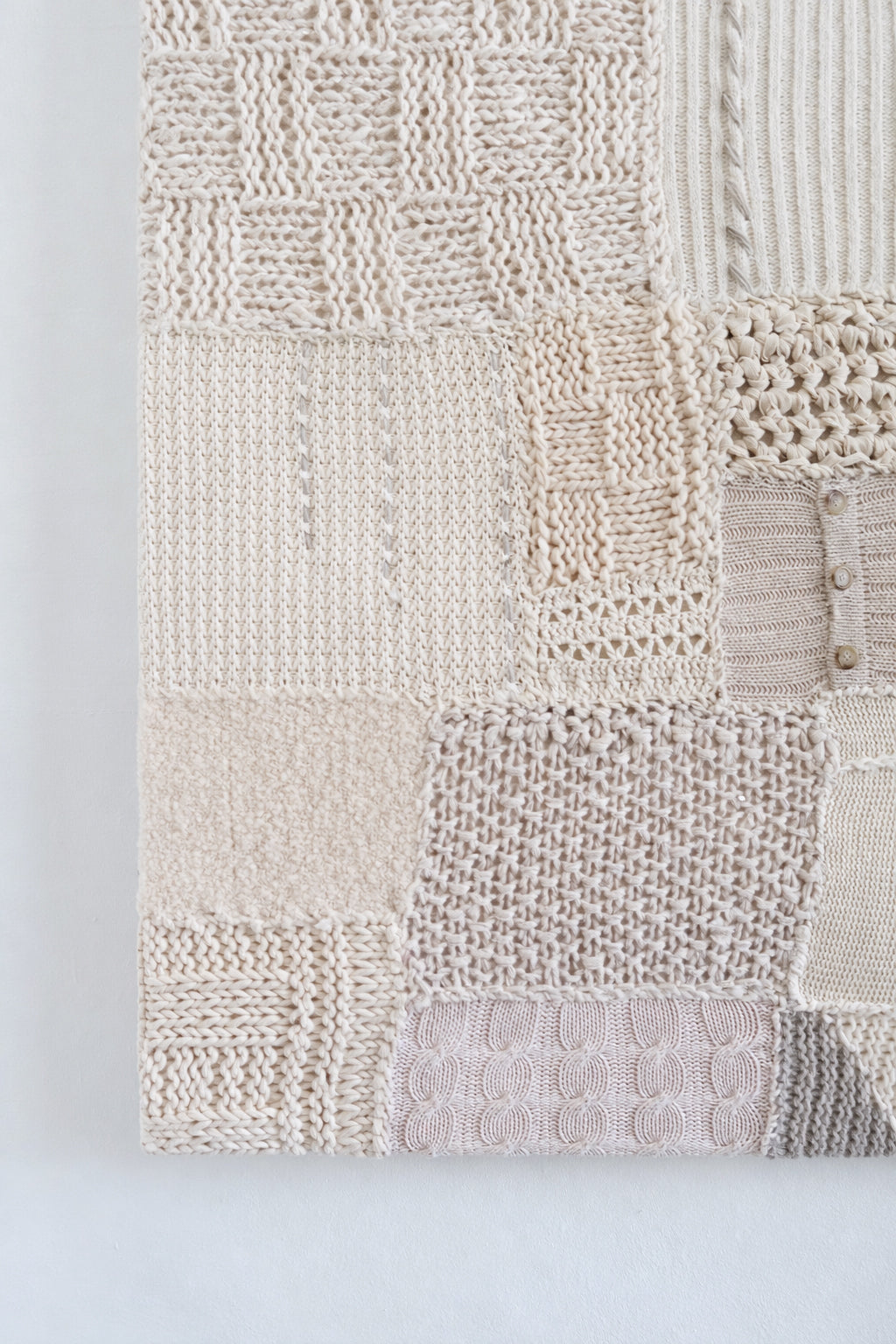 Mixed knit stitch patterns including seed stitch and box stitch in neutral patchwork textile art in cream knit in Los Angeles