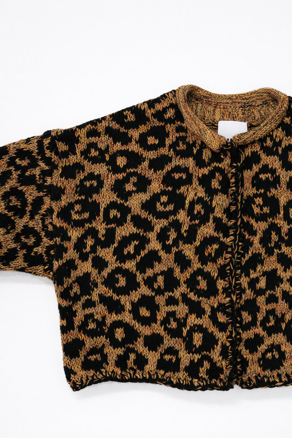 Armhole detail of leopard knit cardigan showing texture and construction