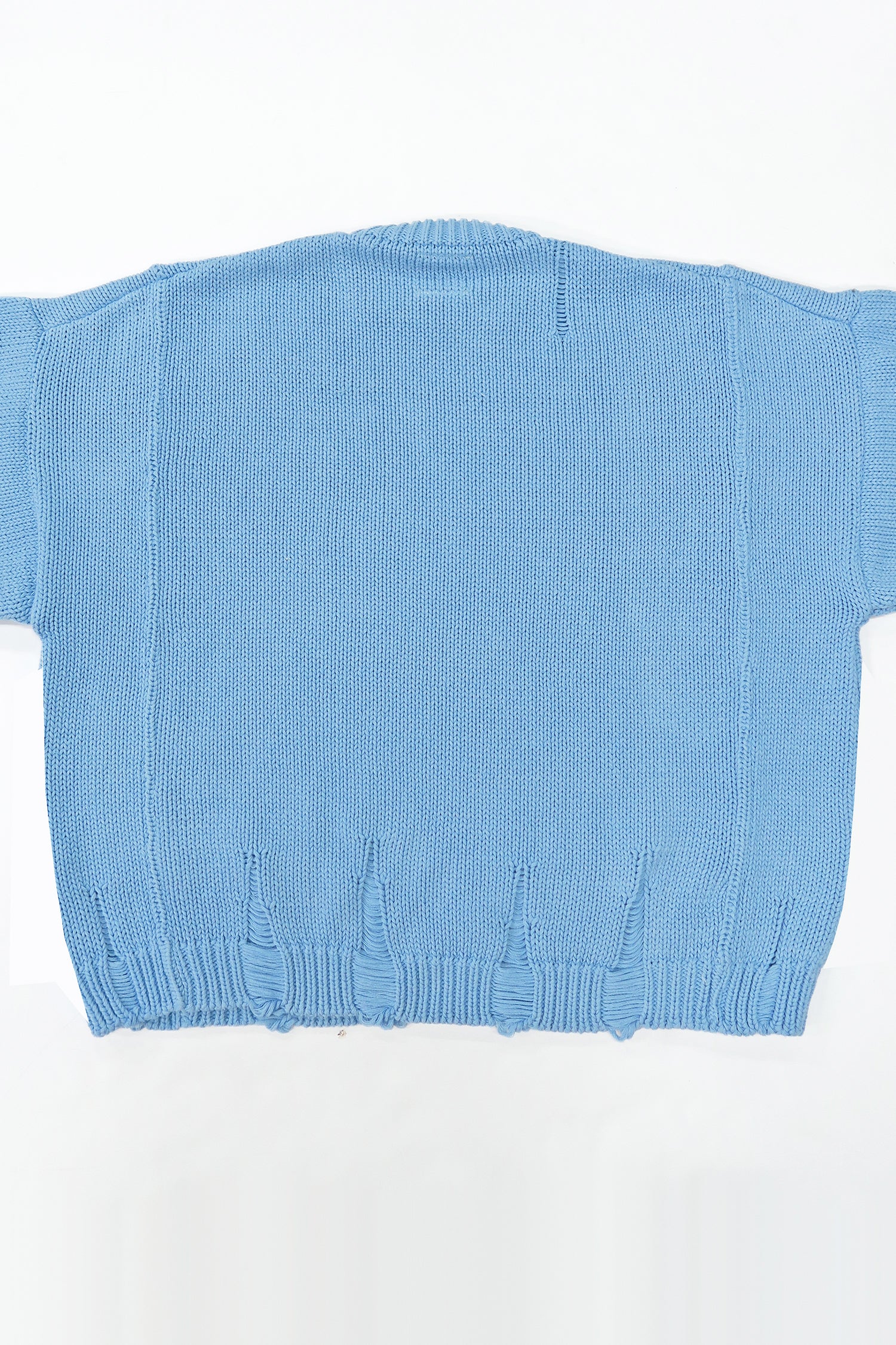 Back view of oversized blue knit sweater showing three panel construction and relaxed silhouette