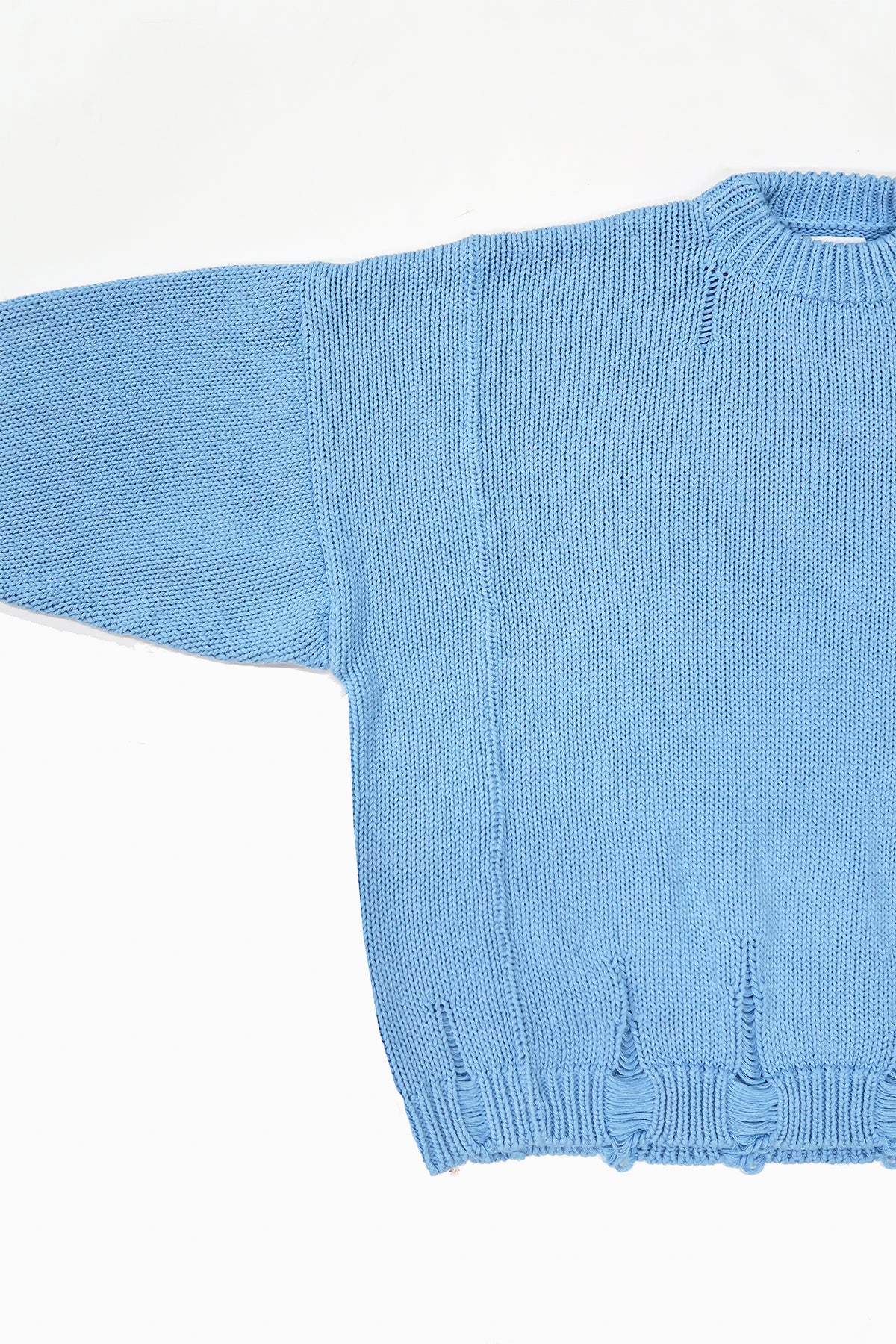 Detail of wide armhole on oversized blue knit sweater showing relaxed fit and panel construction