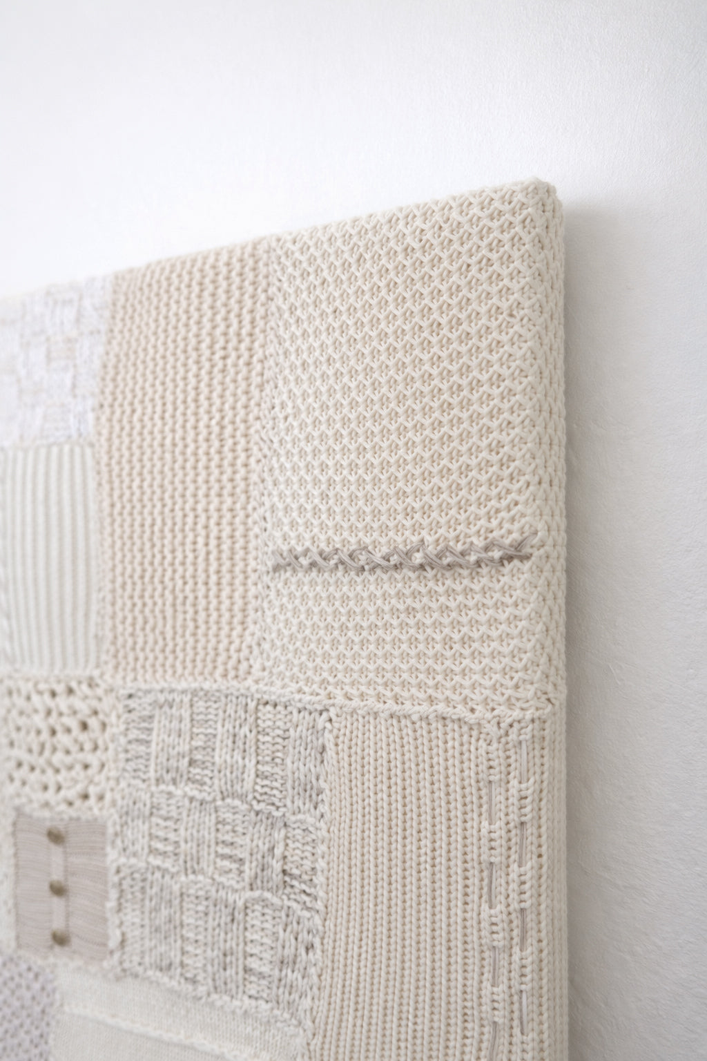 Lace knit and hand stitch detail in handcrafted textile artwork made from cotton and cashmere yarns