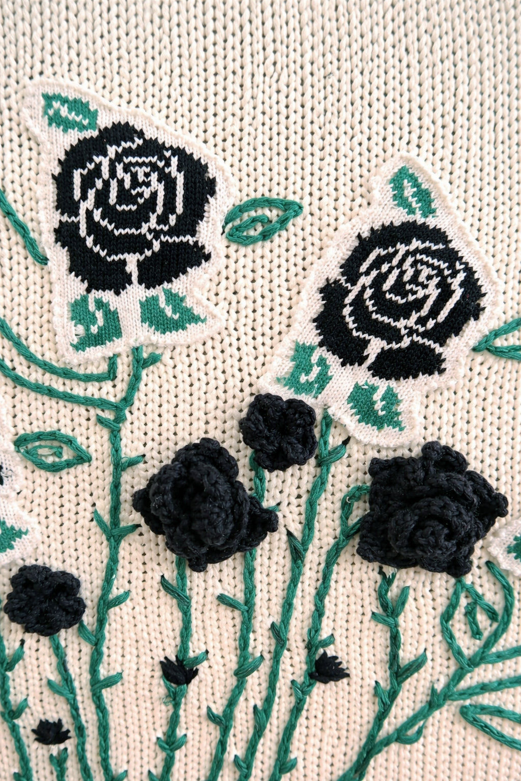 detail of dimensional crocheted black roses on hand loomed textile wall art