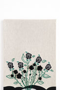 close up of hand loomed cotton knit background textile with embroidered vines and black rose details
