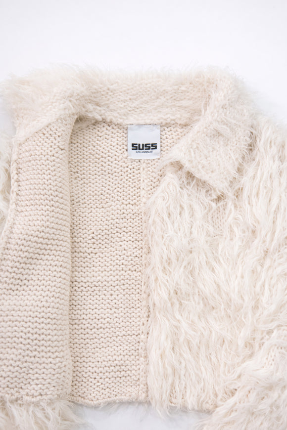 Close-up of hand loomed cotton knit base open front with layered cream viscose fringe detailing