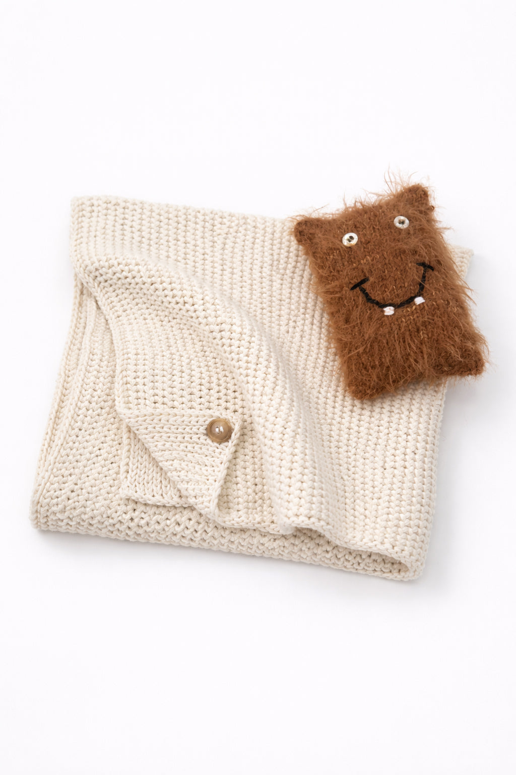 Cream baby knit cotton blanket with handmade fuzzy monster toy for infants