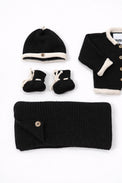 Close up of cotton knit black and cream baby beanie and booties handmade knit set