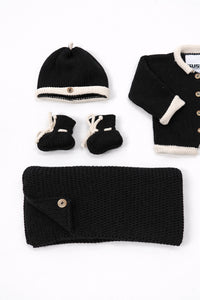 Close up of cotton knit black and cream baby beanie and booties handmade knit set