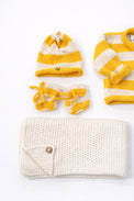 Close up of cotton yellow striped baby beanie and booties handmade knit set