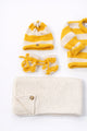Close up of cotton yellow striped baby beanie and booties handmade knit set
