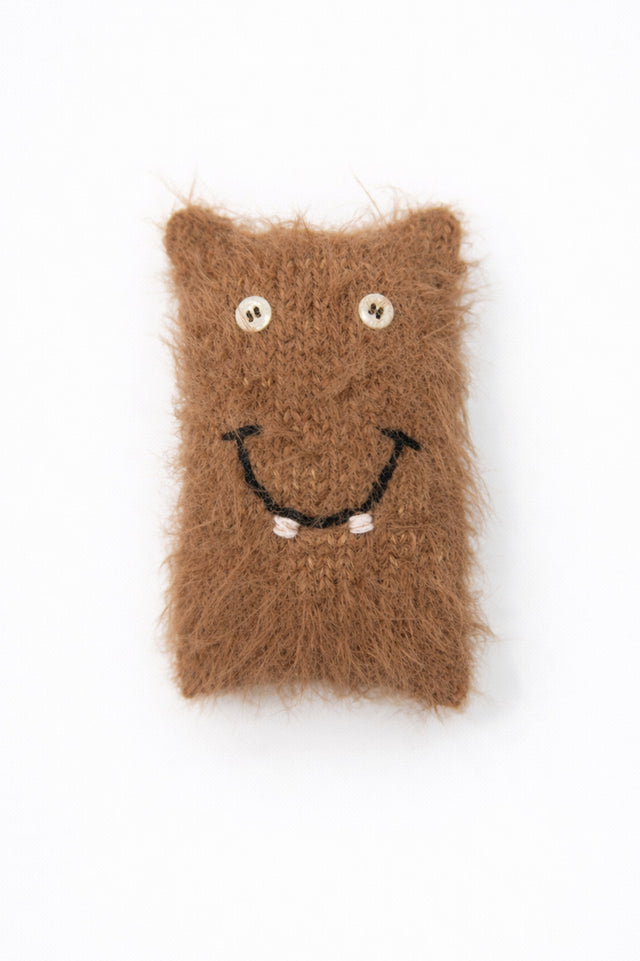 Handmade fuzzy monster baby toy with button eyes and smile in recycled cotton