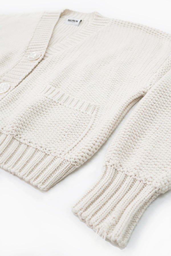 Angle view of the Suss Knits recycled cotton hand loomed cardian in a textured cream stitch