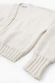 Angle view of the Suss Knits recycled cotton hand loomed cardian in a textured cream stitch
