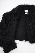 Close-up of hand loomed cotton knit base with layered black viscose fringe detailing