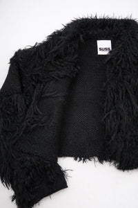 Close-up of hand loomed cotton knit base with layered black viscose fringe detailing
