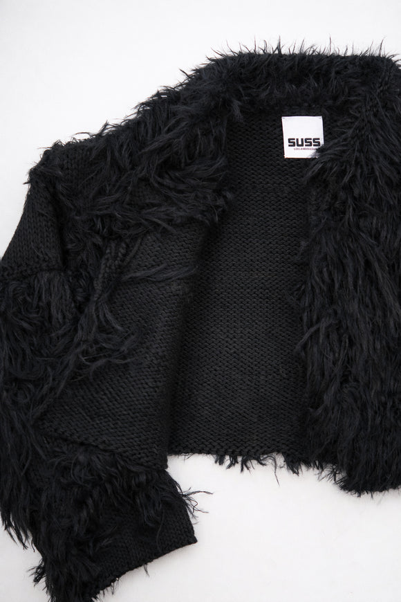 Close-up of hand loomed cotton knit base with layered black viscose fringe detailing
