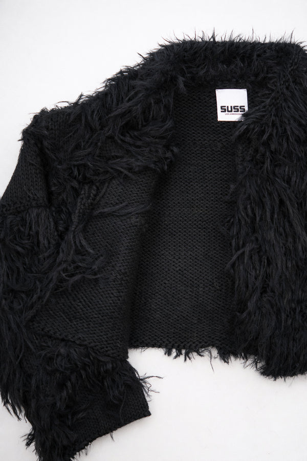 Close-up of hand loomed cotton knit base with layered black viscose fringe detailing