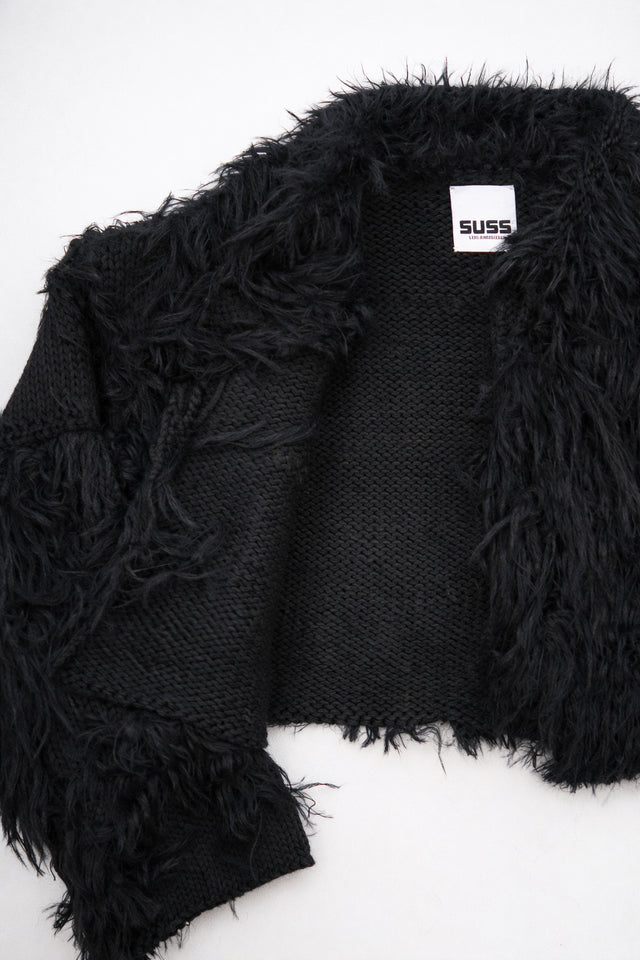 Close-up of hand loomed cotton knit base with layered black viscose fringe detailing