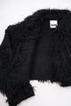 Close-up of hand loomed cotton knit base with layered black viscose fringe detailing
