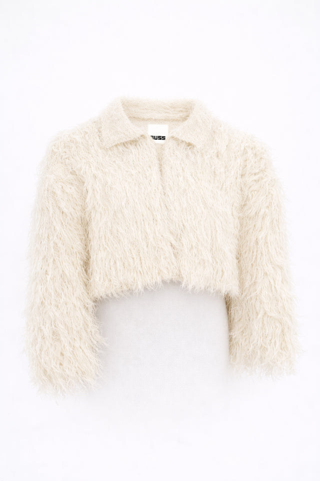 Cropped cream fringe jacket shown on form, featuring hand loomed cotton knit base with long shaggy fringe