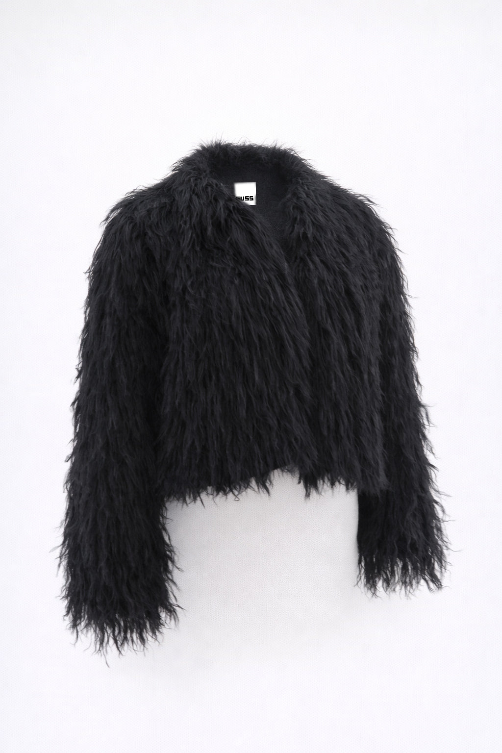 Cropped black fringe jacket shown on form, featuring hand loomed cotton knit base with long shaggy fringe