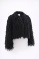 Cropped black fringe jacket shown on form, featuring hand loomed cotton knit base with long shaggy fringe
