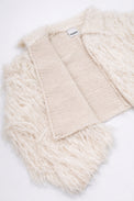 Detailed view of cream fringe knit jacket showing contrast between structured knit inside and soft fringe at angle