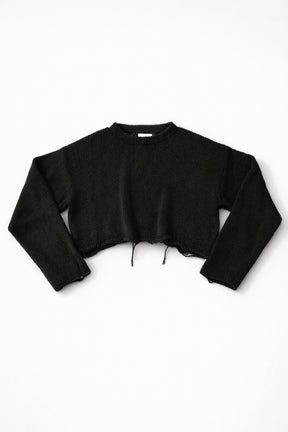 Black cotton cropped knit sweater laid flat with soft texture and raw hem detail