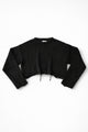 Black cotton cropped knit sweater laid flat with soft texture and raw hem detail