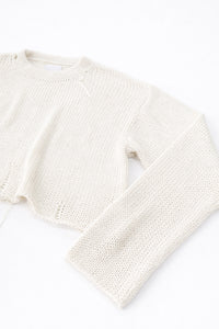 Side detail of raw edge sleeve cuff in cream cotton knit