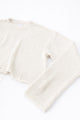 Side detail of raw edge sleeve cuff in cream cotton knit