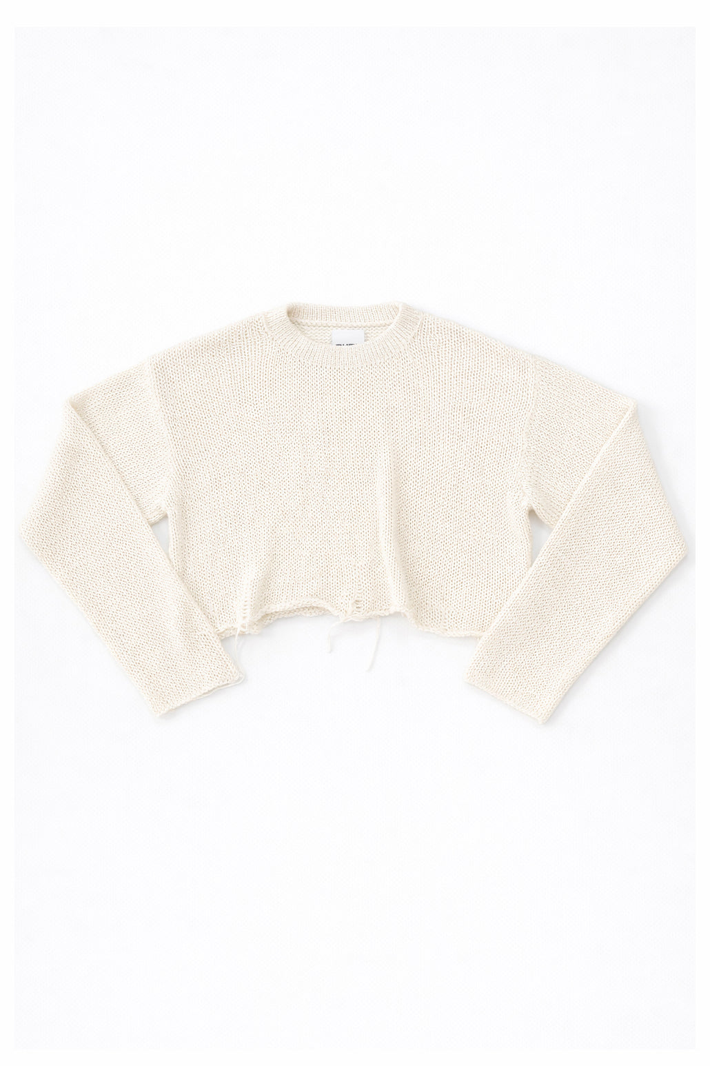 Cream cotton cropped knit sweater laid flat with soft texture and raw hem detail by Suss Knits