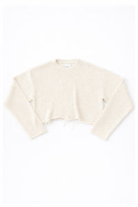 Cream cotton cropped knit sweater laid flat with soft texture and raw hem detail by Suss Knits
