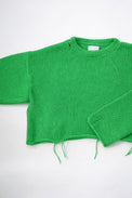 Armhole view of the suss knits light weight hand loomed cropped sweater in a bright green sweater