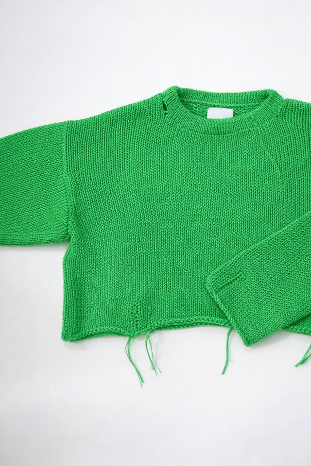 Armhole view of the suss knits light weight hand loomed cropped sweater in a bright green sweater