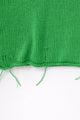 Close up detail of raw hem hand loomed green sweater with drop stitches