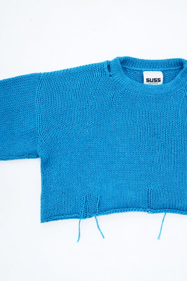 Armhole detail of soft cropped turquoise knit sweater