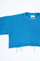 Armhole detail of soft cropped turquoise knit sweater