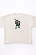 Back view of cream cotton rollneck sweater with a centered black rose