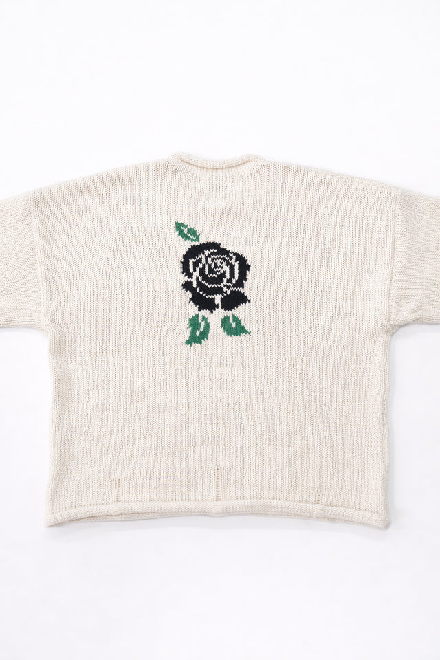 Back view of cream cotton rollneck sweater with a centered black rose