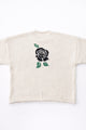 Back view of cream cotton rollneck sweater with a centered black rose