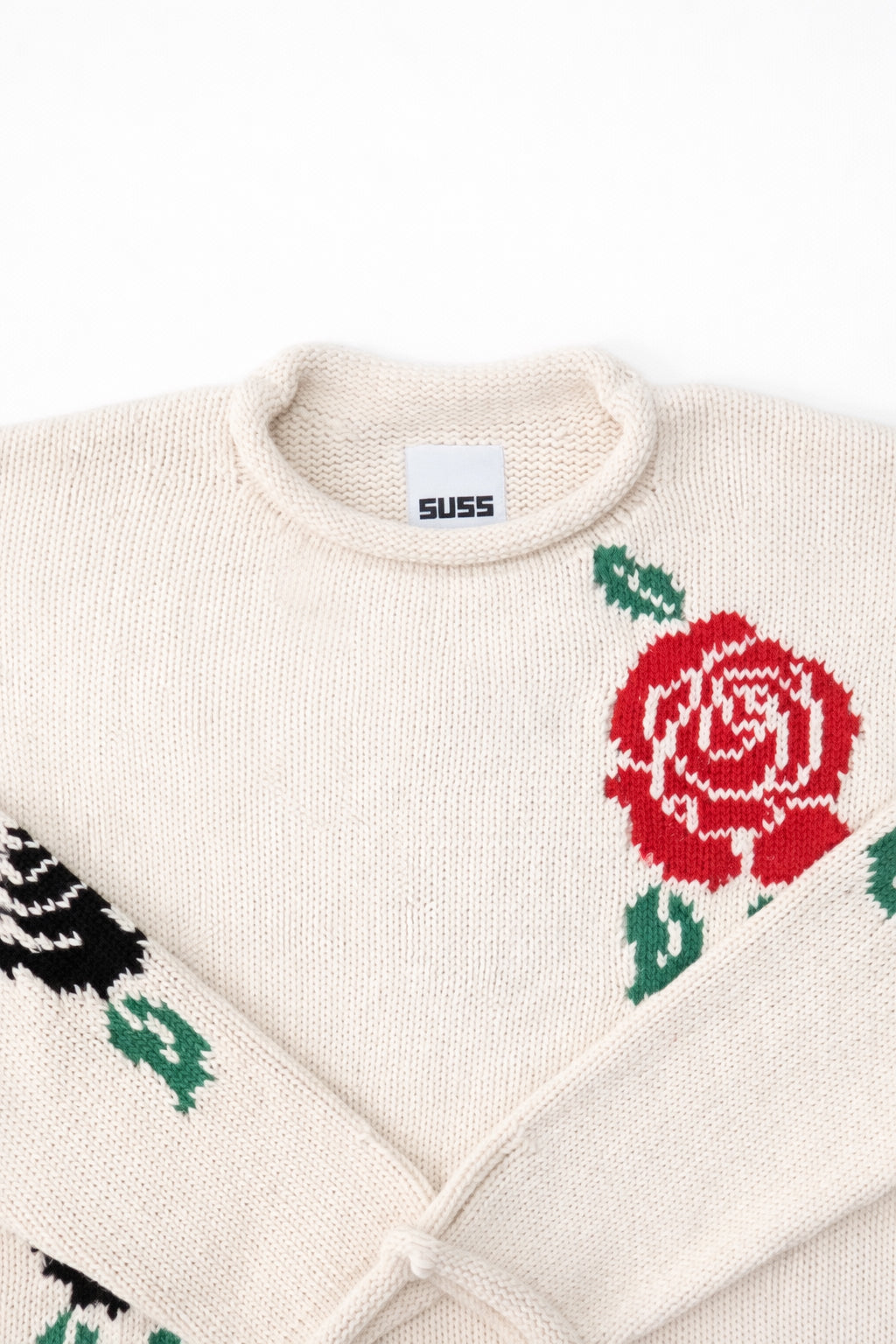 Neckline detail of the Suss rose intarsia rollneck swedater hand loomed in cream recycled cotton