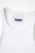 Close-up of white ribbed knit tank neckline with subtle tattered edge detail and Suss label