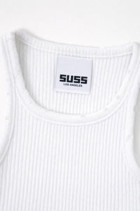 Close-up of white ribbed knit tank neckline with subtle tattered edge detail and Suss label